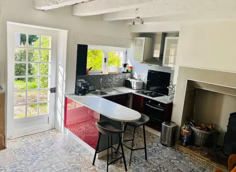 De keuken met bar, gasfornuis en de oude schouw