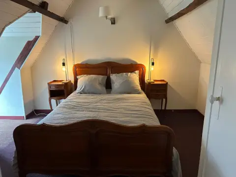 Slaapkamer boven met een Frans houten bed en nachtkastjes
